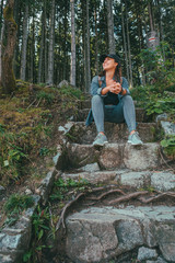 Fototapeta premium smiling woman hiker sitting at stone stairs
