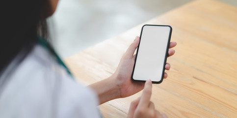 Close-up view of young female doctor touching blank screen smartphone