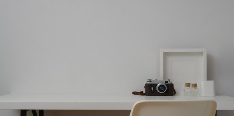Minimal workspace with mock up frames and camera in white wall background