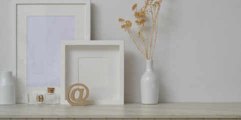 Minimal workspace with mock up frames and decorations in white wall background