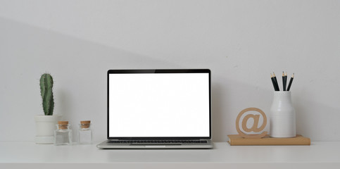 Open blank screen laptop computer with office supplies and decorations