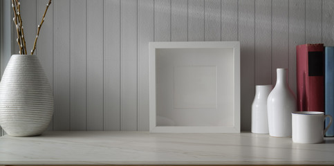 Minimal workspace with mock up frame and copy space with ceramic vase decorations