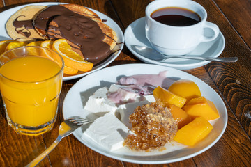 Breakfast of many dishes and drinks on a wooden table, closeup. Food concept