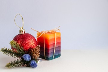 Festive composition of decorative candles and Christmas toys on a light background
