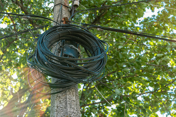 A fiber optic cable harness for communication weighs on a concrete column. Telecommunications and Internet. 