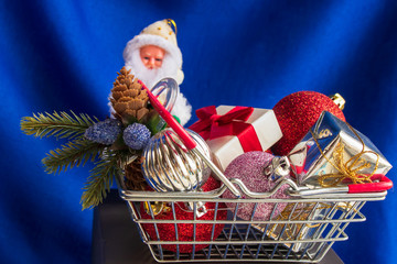 Festive basket with gifts and Christmas toys close up on a bright blue background