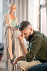 Bearded man feeling upset while speaking with psychoanalyst