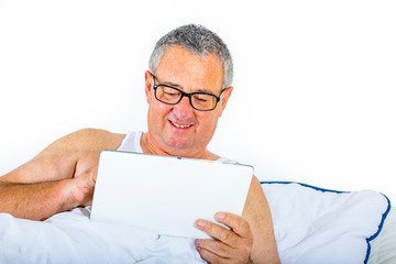 Man with tablet pc is lying in bed