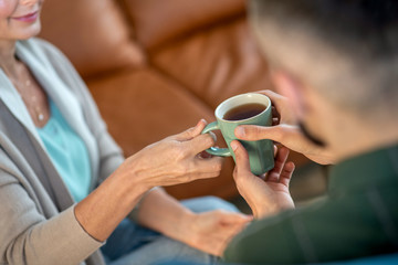 Psychoanalyst giving tea to her patient while having conversation