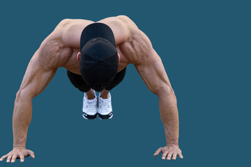 Fitness model man, very muscular doing push-ups in arm extension position