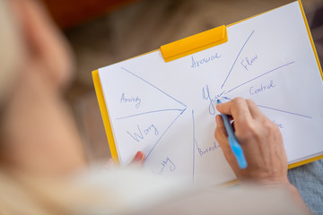 Psychologist analyzing mental state of client while making notes