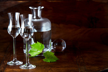 Grappa still life with two glasses and copy space - obrazy, fototapety, plakaty