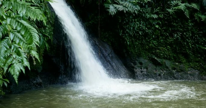 beautiful natural cascade in Guadeloupe. fast moving cinematic shot. green exotic Caribbean scenic water fall forest. holiday famous hiking jungle beauty destination in france antilles island