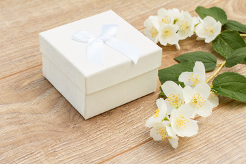 Gift box with jasmine flowers on the background.