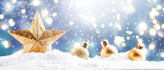 Christmas background with golden star. New Year's decor. Christmas balls in smowdrifts and golden...