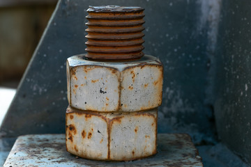 A large rusted bolt with screw. Part of a huge metal construction. 