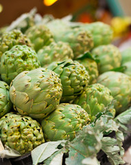 Obraz premium Fresh artichokes on market counter