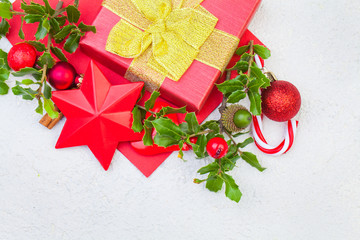 Christmas composition. Xmas gift box, holly berries and red decorations