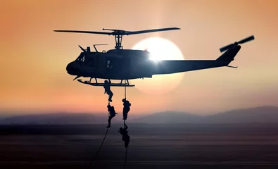 Foto op Plexiglas Helikopter Militaire commando& 39 s helikopter daalt tijdens zonsopgang