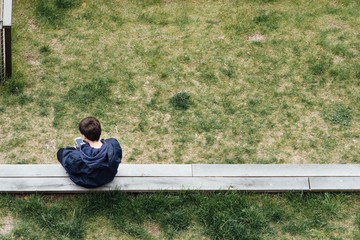 un jeune assis sur un banc regardant son smartphone téléphone portable et la solitude et dépendance des réseaux sociaux