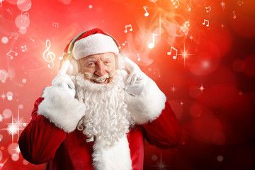 Portrait of Santa Claus listening to music on dark background