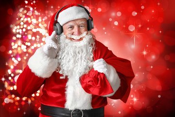 Portrait of Santa Claus listening to music on color background