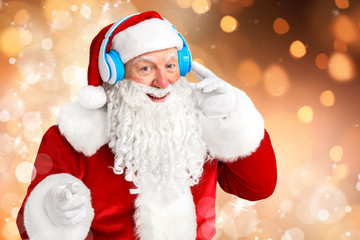 Portrait of Santa Claus listening to music on color background