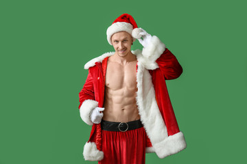 Young athletic Santa Claus on color background