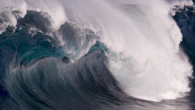 A glassy wave barrelling along a shallow reef break, first showing beautiful reflections on the wave face before gurgling and foaming. Slow motion and close up on a sunny blue day.