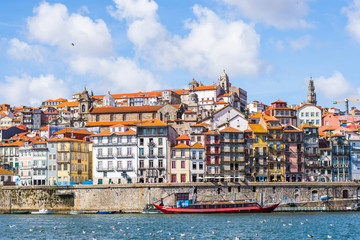Fototapeta na wymiar The skyline of Porto in Portugal with a red boat on the river
