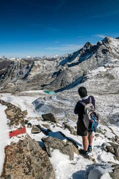hiker enjoyes view over Macun Lakes in autumn with the first snow
