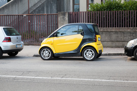 Black and yellow Smart car parked on urban roadside