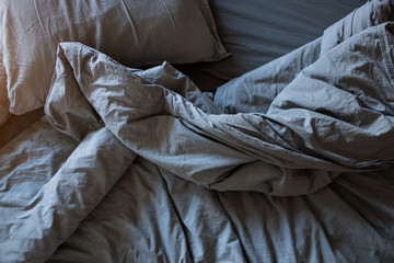 Obraz premium Blue bed sheets and pillows after night's sleep.