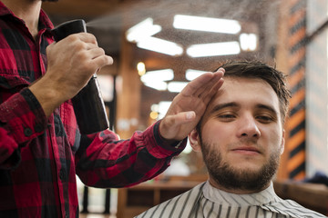 Haidresser spraying the client hair