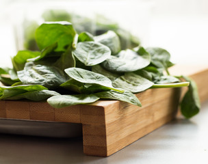 Baby spinach leaf on the kitchen wooden board