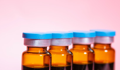 Blank medicine oral liquid glass bottle closeup and pink background