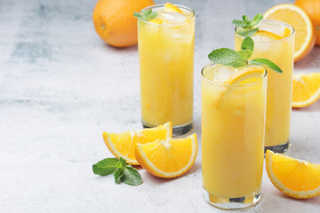 Glasses full of orange juice with ice	
