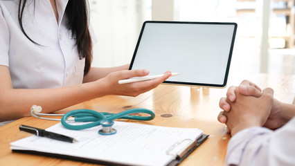 Doctor using tablet discussion something with patient.