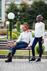 Fototapeta premium Two young modern fashionable, attractive, tall and slim african muslim womans in hijab or turban head scarf posed together.