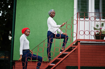 Two young modern fashionable, attractive, tall and slim african muslim womans in hijab or turban...