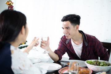 Asian young couple enjoying a romantic dinner  evening drinks while sitting at the dinning table on the kitchen together
