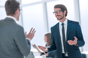 businessman talking with a colleague standing in the office
