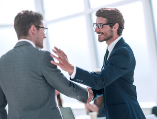 smiling business people greet each other with a handshake