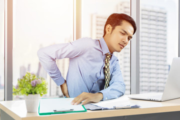 Fototapeta premium Asian Business men with back pain sin an office and serious about the work done until the headache on working hard