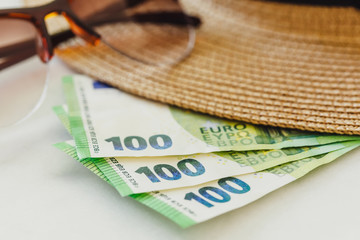 Sun hat with sunglasses and 100 hundredth euro banknotes. Vacation concept