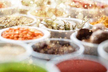 Various colorful spices in bowls on wooden table