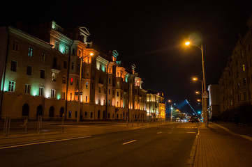 Naklejka na ściany i meble Night city with luminous streets. Buildings with beautifully colored lights.