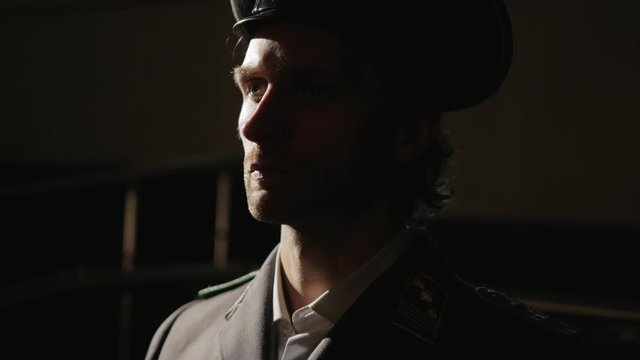 Portrait of adult SS Nazi officer  in a dark room 