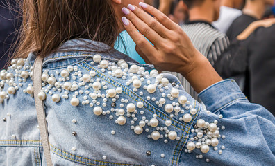 Back view of a girl in a denim jacket with rhinestones