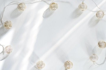 Christmas light balls with sunlight rays on a white background. Flat lay copy space